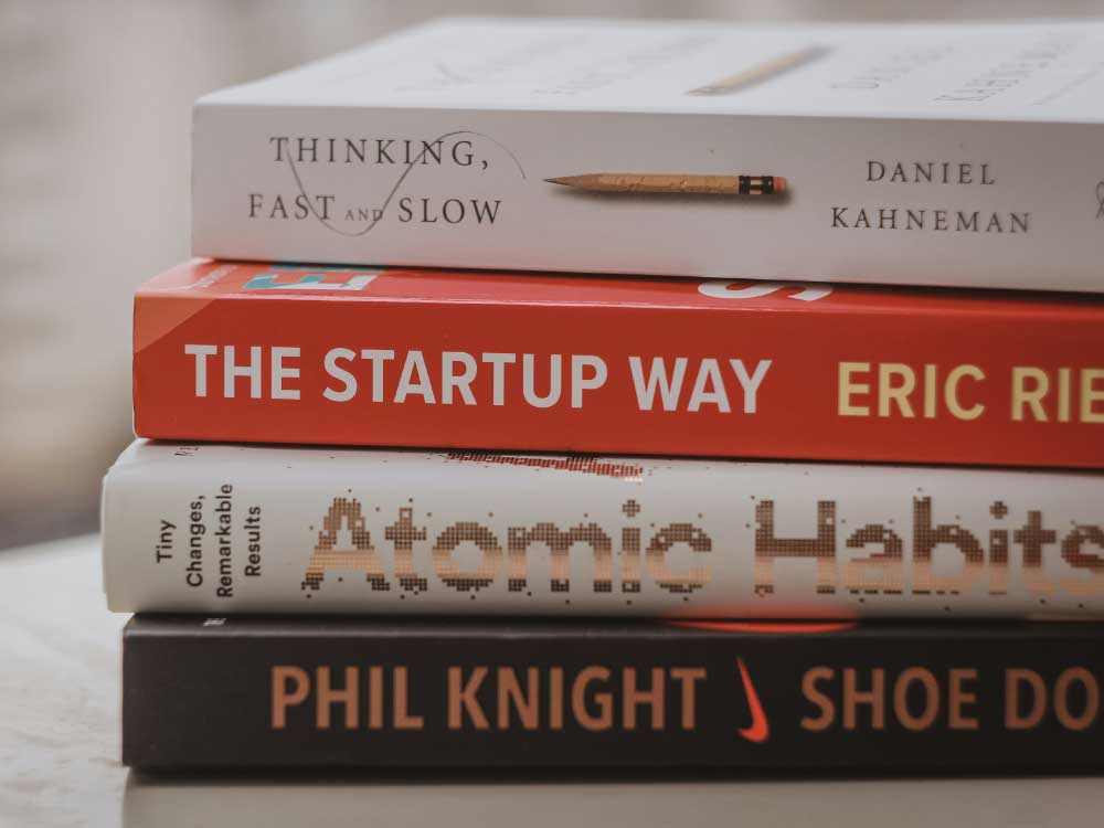 A stack of four business books